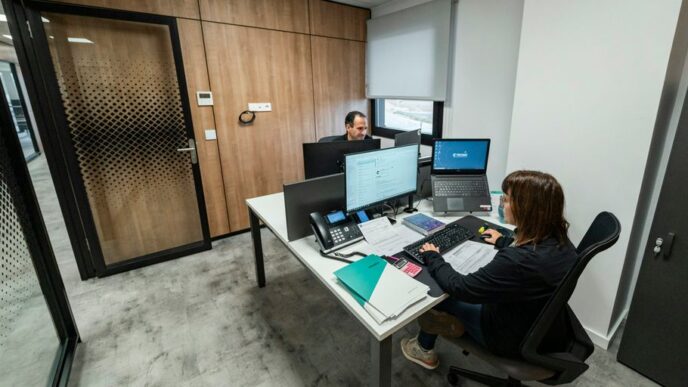 People work at desks in a modern office.
