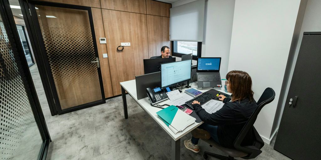 People work at desks in a modern office.
