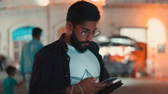 man in black jacket holding smartphone