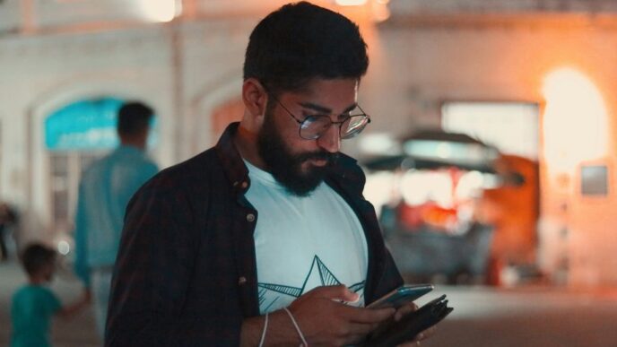 man in black jacket holding smartphone