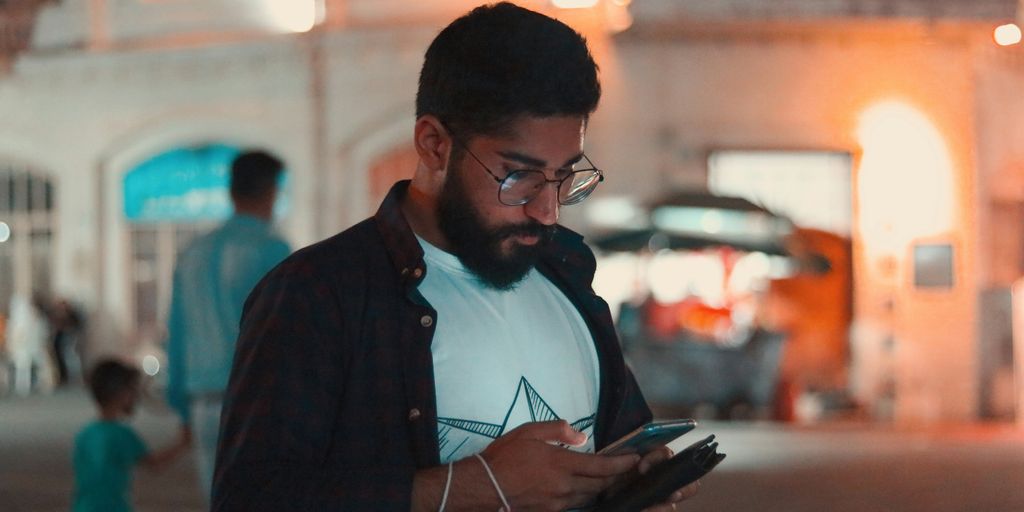 man in black jacket holding smartphone