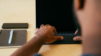 man typing on laptop