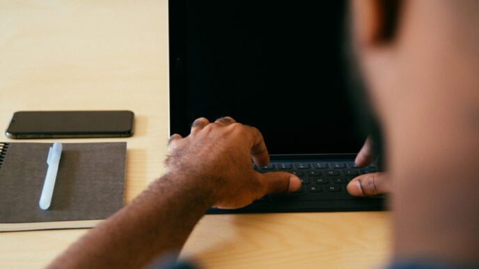 man typing on laptop