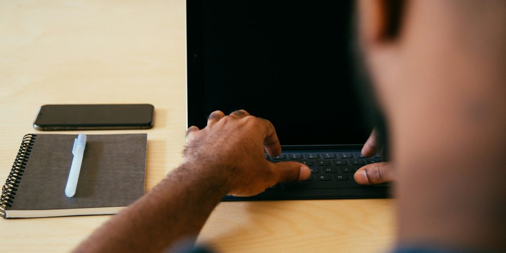 man typing on laptop