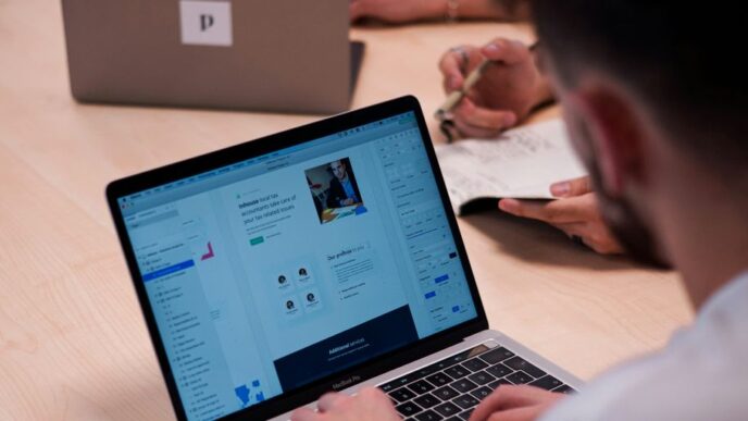 person using macbook pro on table
