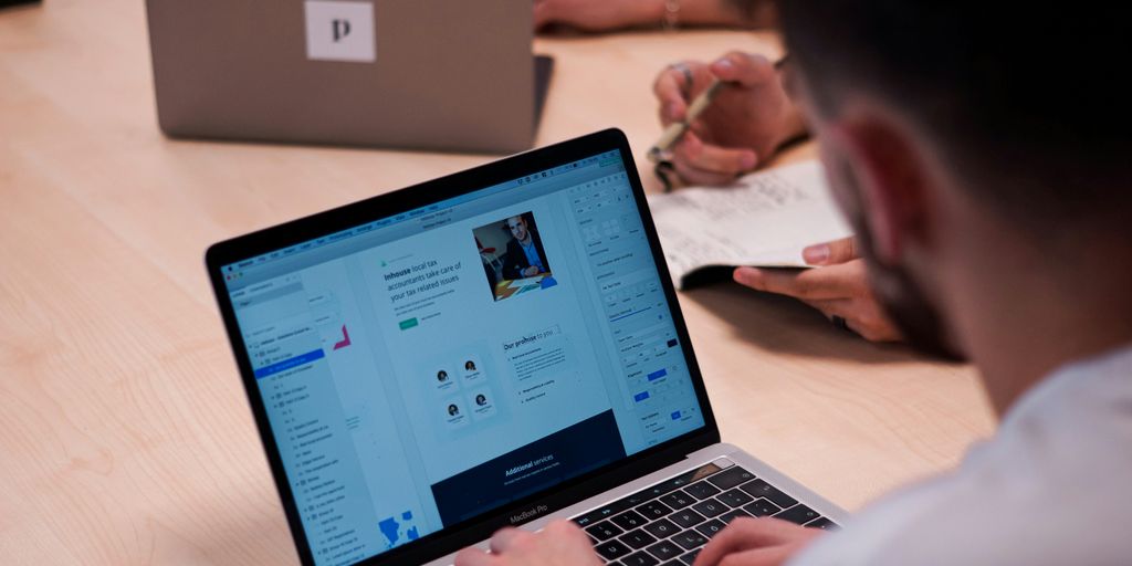 person using macbook pro on table