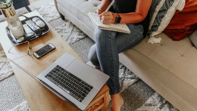 woman in black and white tank top and blue denim jeans sitting on white couch