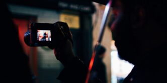 person under the umbrella holding digital camera