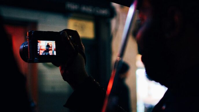 person under the umbrella holding digital camera