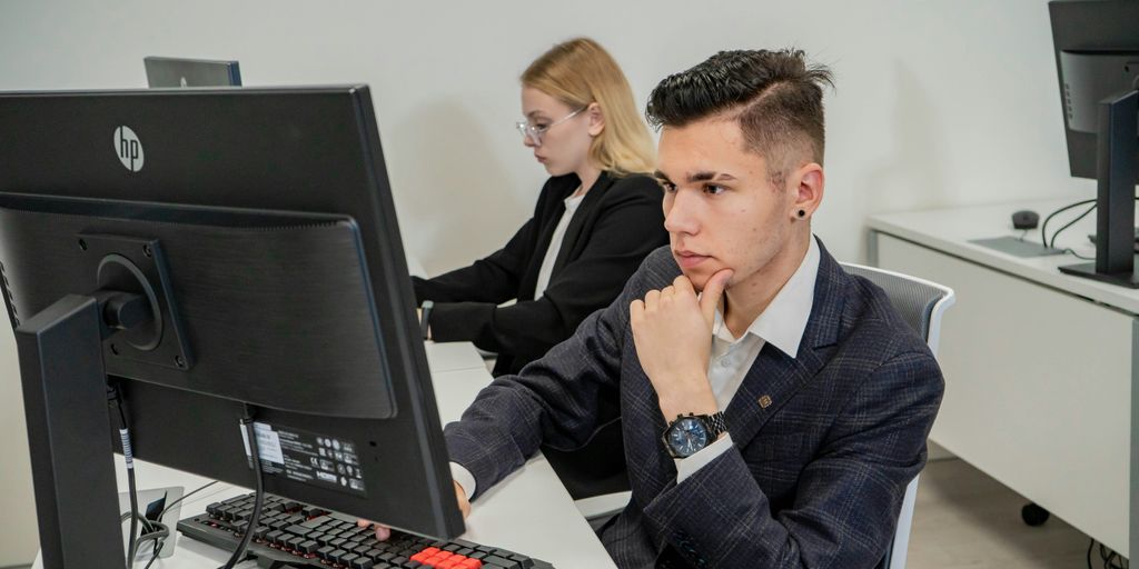 a man sitting at a desk in front of a computer