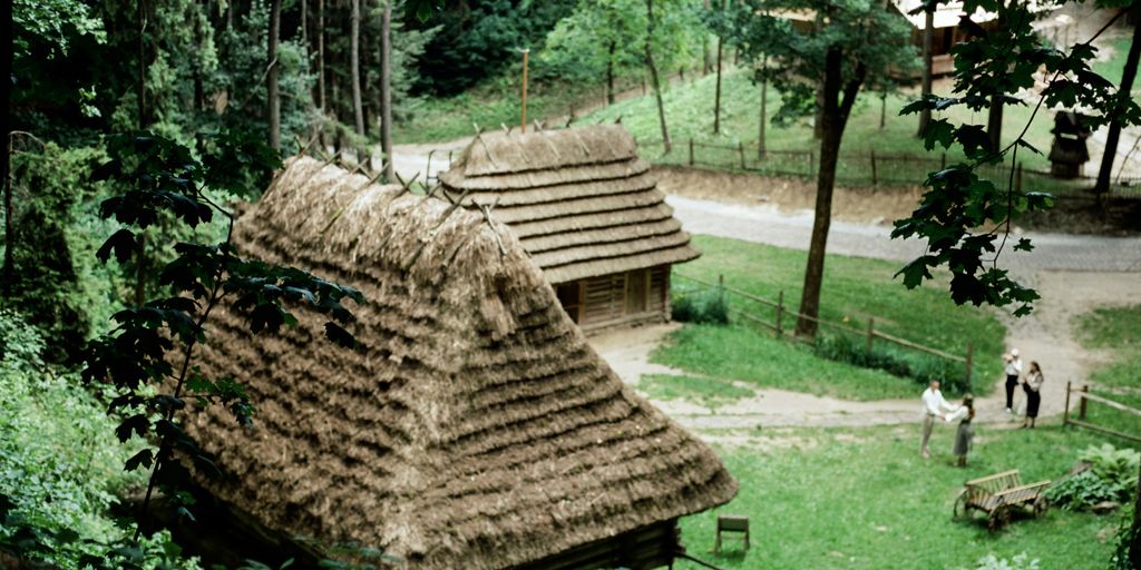 Thatched roof huts nestled in a lush green jungle clearing.