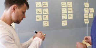 man in white long sleeve shirt writing on white board