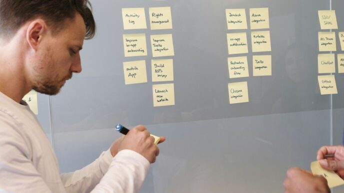 man in white long sleeve shirt writing on white board