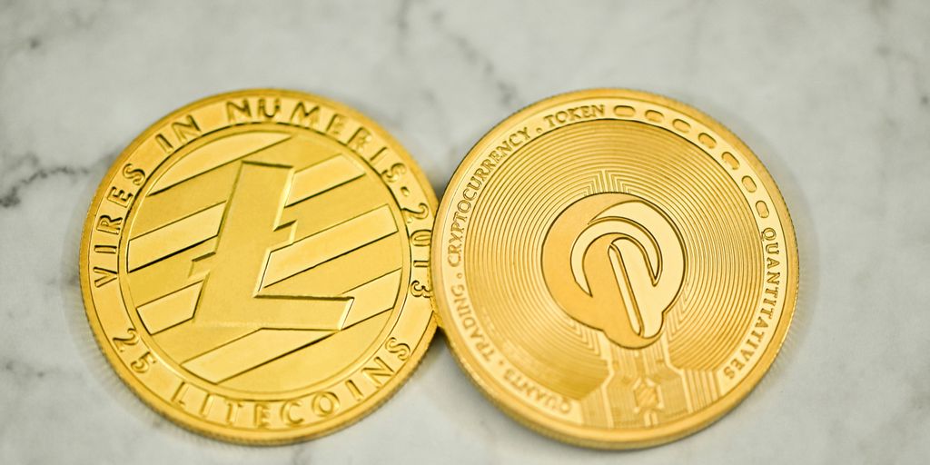 a close up of two gold coins on a marble surface