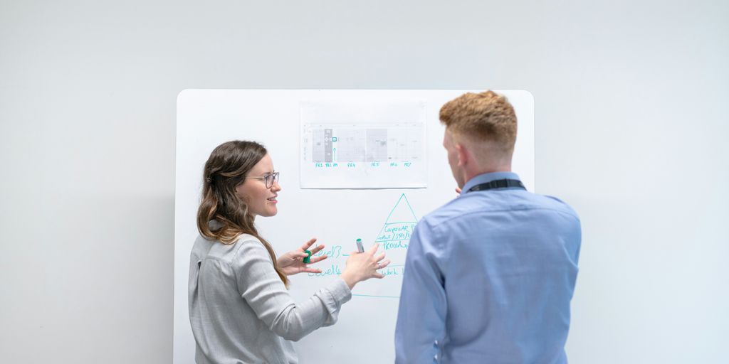 man in blue long sleeve shirt holding woman in gray sweater