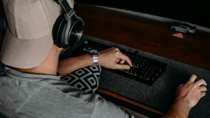 a man wearing headphones and sitting at a desk with a computer