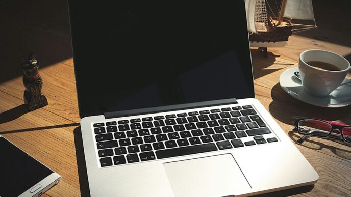 A laptop computer sitting on top of a wooden desk