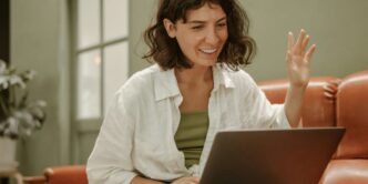 a woman sitting on a couch using a laptop computer