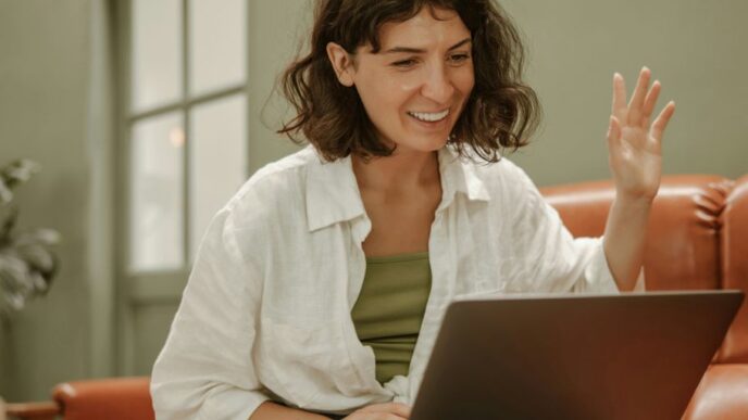 a woman sitting on a couch using a laptop computer