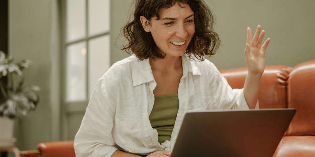 a woman sitting on a couch using a laptop computer