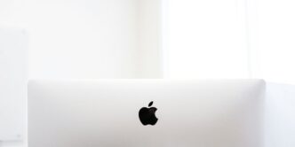 silver macbook on brown wooden table