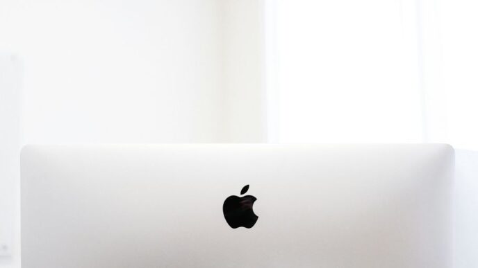 silver macbook on brown wooden table