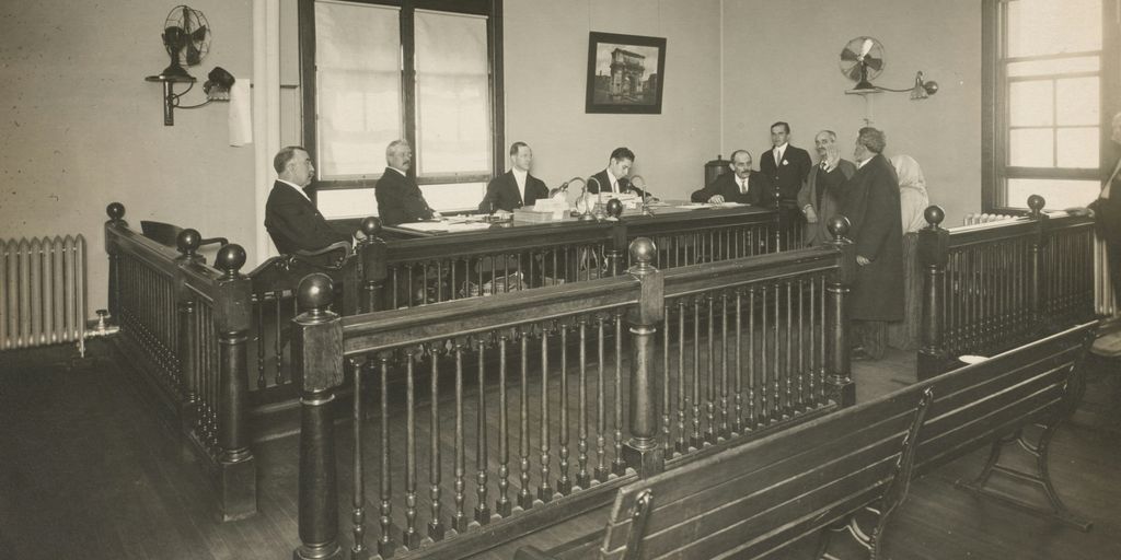 a group of men standing around a wooden desk