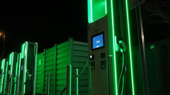 a row of green gas pumps at night