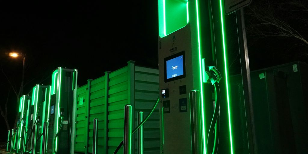 a row of green gas pumps at night
