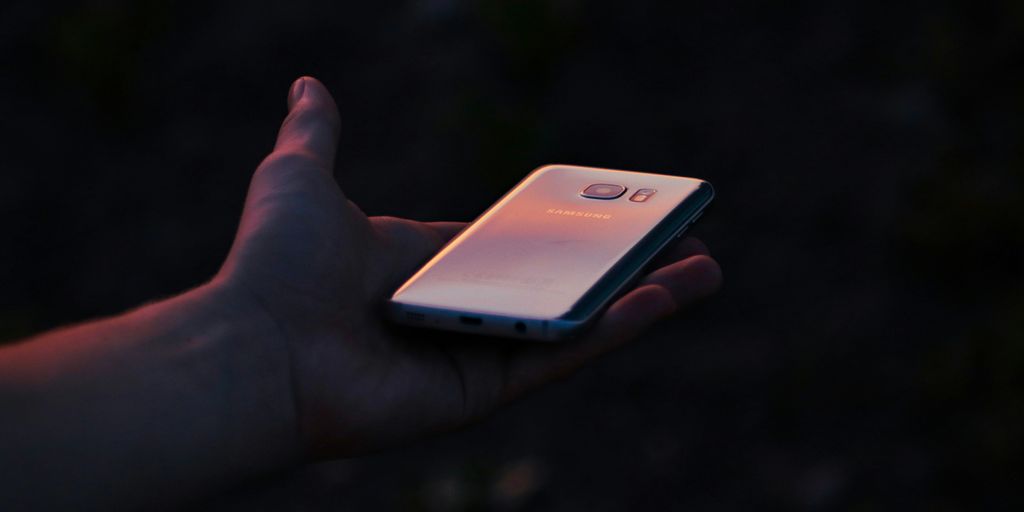 a person holding a cell phone in their hand