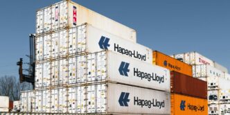 Shipping containers are stacked in a large pile.