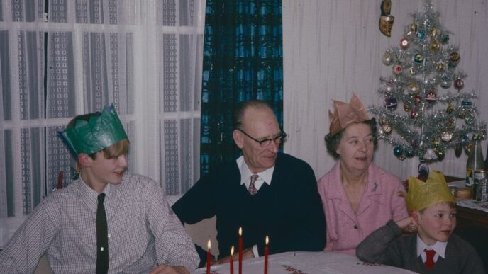a group of people sitting around a table with a christmas tree