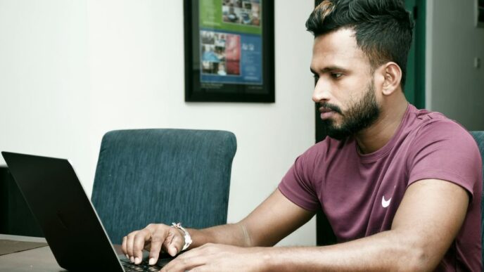 a man sitting in front of a laptop computer