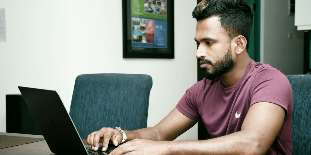 a man sitting in front of a laptop computer