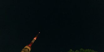 A very tall tower with a clock on it's side