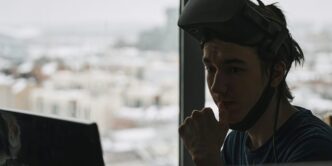 man in blue tank top wearing black cap