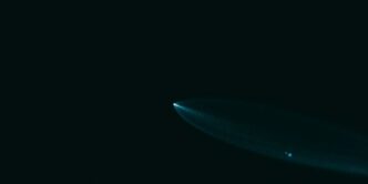 A surfboard is floating in the dark water
