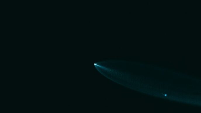 A surfboard is floating in the dark water