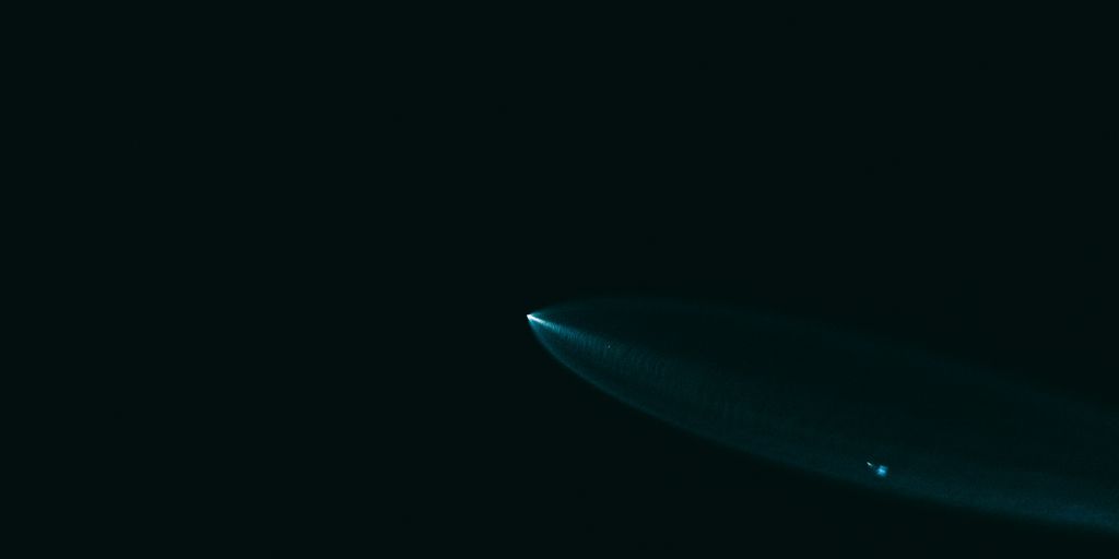 A surfboard is floating in the dark water