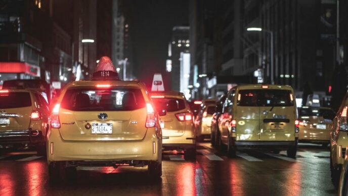 vehicles on road beside buildings during nighttime