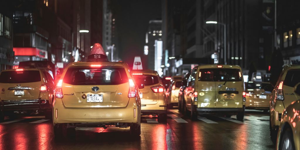 vehicles on road beside buildings during nighttime