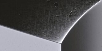a close up of a metal surface with drops of water on it