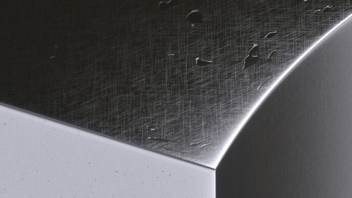 a close up of a metal surface with drops of water on it