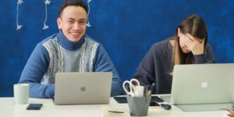 woman in gray sweater using silver macbook