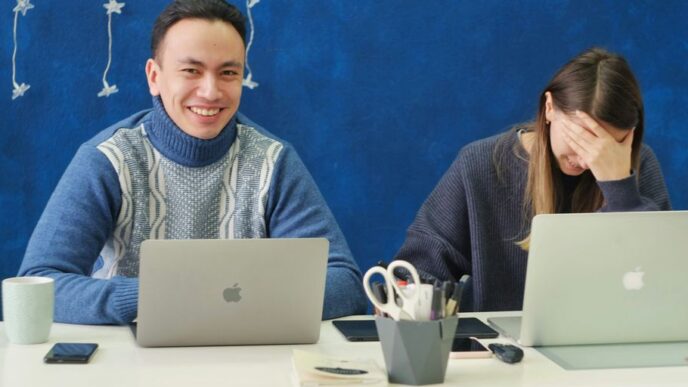 woman in gray sweater using silver macbook