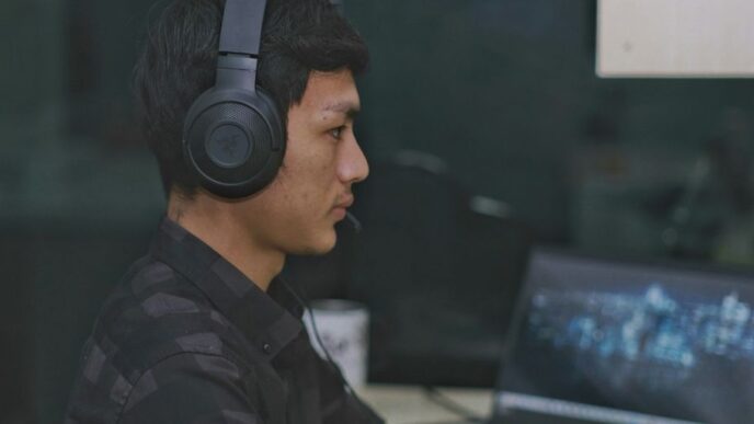 a man wearing headphones is using a laptop