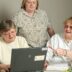 woman in white cardigan sitting beside woman in black and white floral shirt
