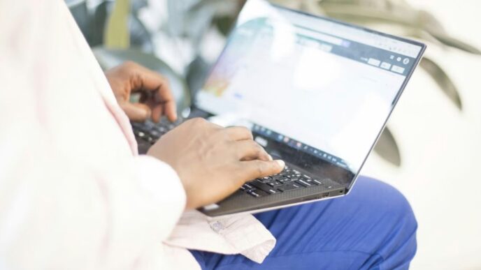 a person using a laptop computer on their lap
