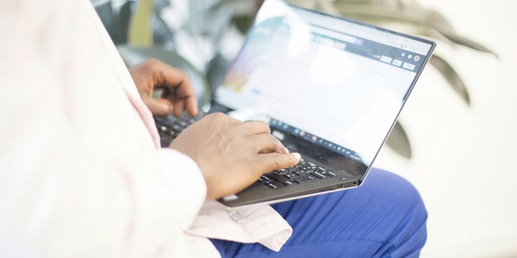 a person using a laptop computer on their lap