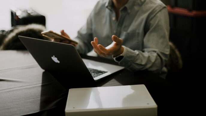a man sitting at a table with a laptop in front of him